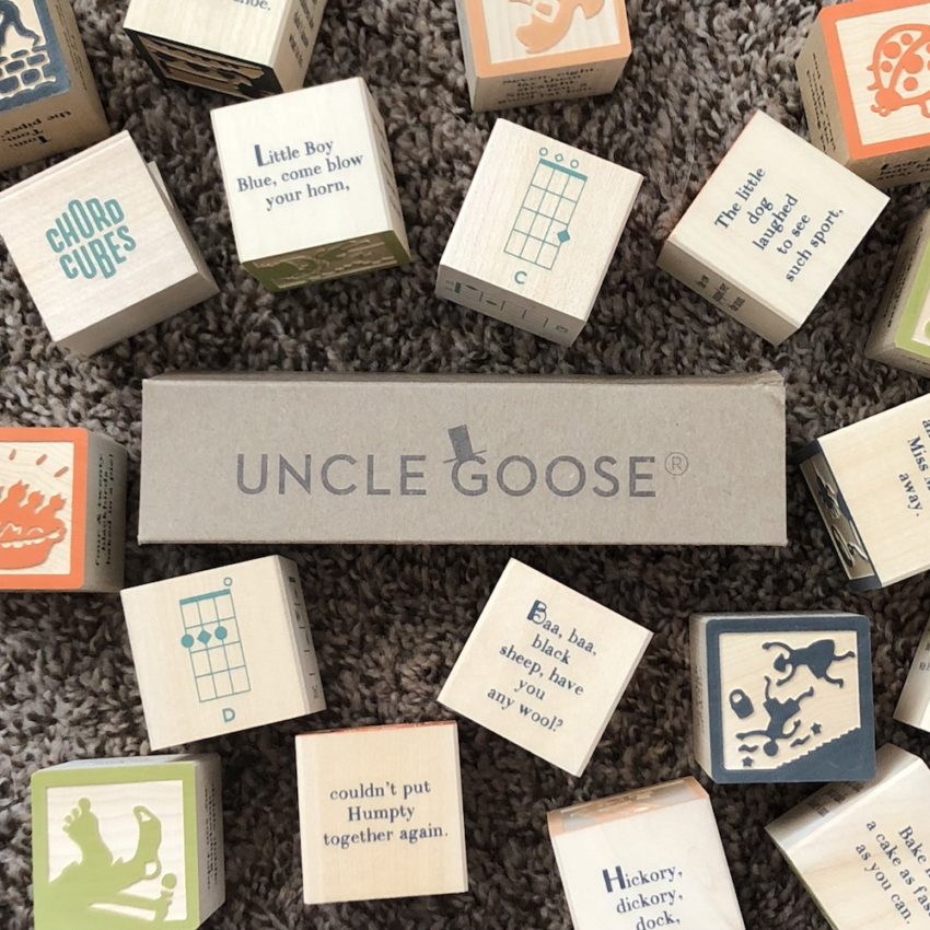 Wooden blocks with nursery rhymes, ukulele chords, and guitar chords, to use in the music room.