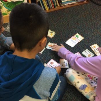 Children working with cards in a learning center.